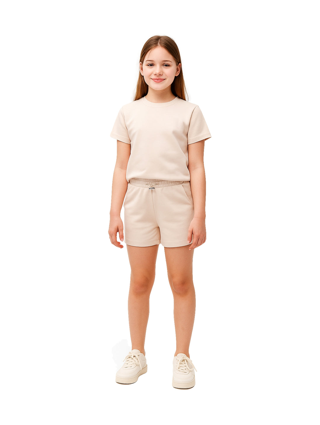 Niña vistiendo un conjunto de camiseta y shorts en color beige con tenis a juego.