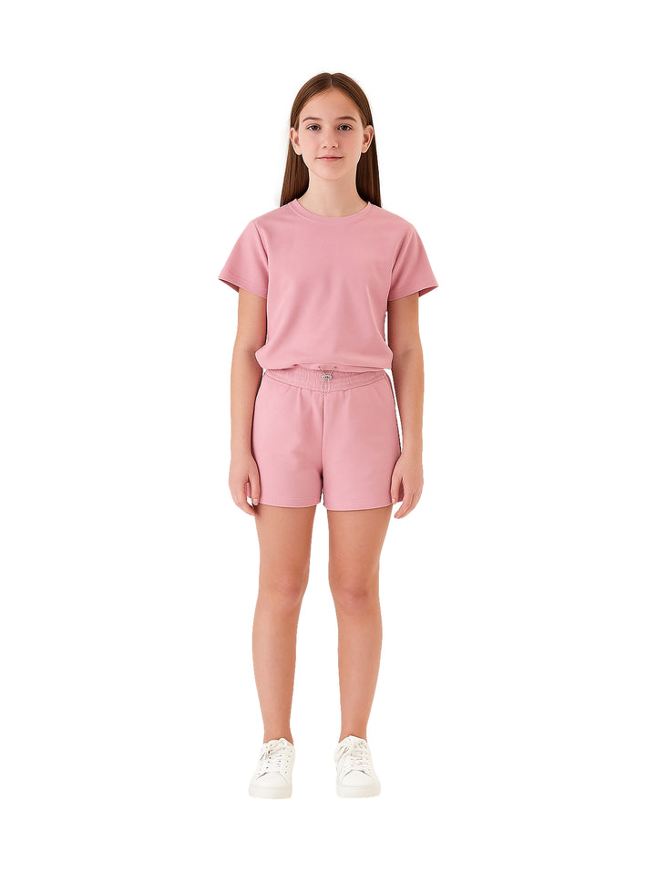 Niña vistiendo un conjunto de camiseta y shorts en color rosa