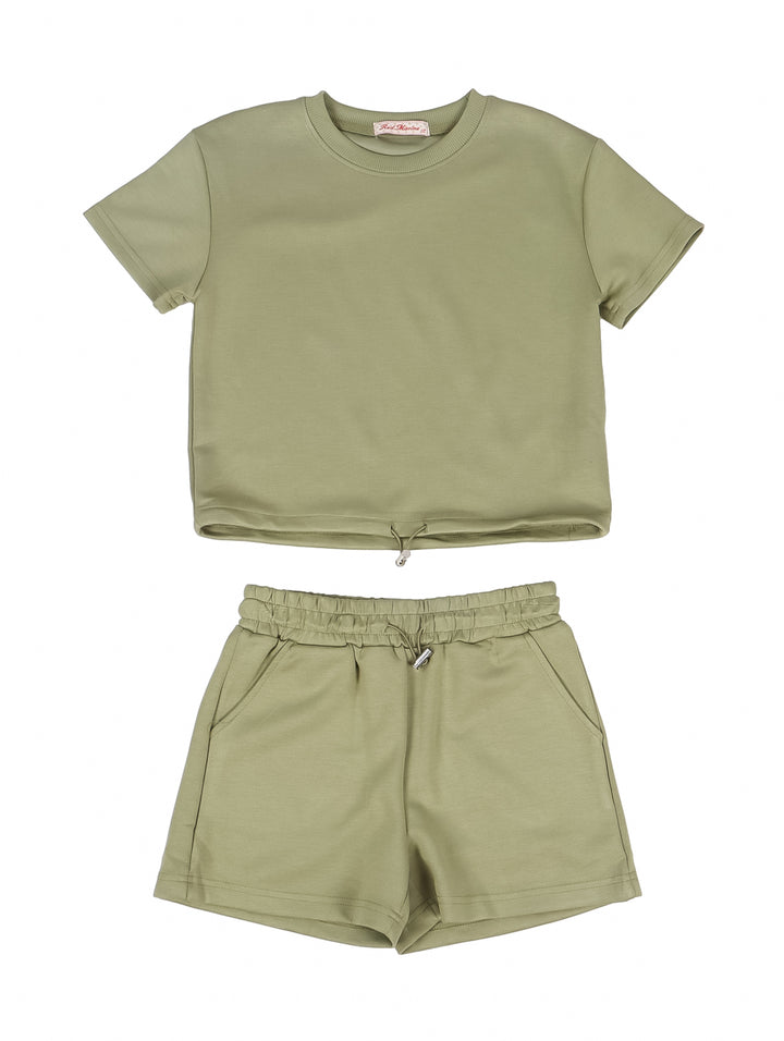 Niña vistiendo un conjunto de camiseta y shorts en color verde oliva.