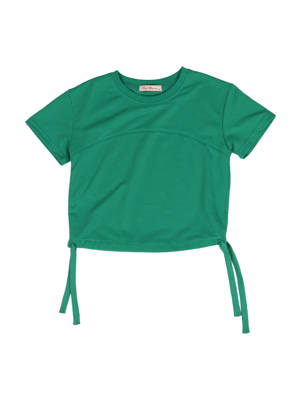 Niña vistiendo un conjunto de camiseta y short color verde con tenis blancos.