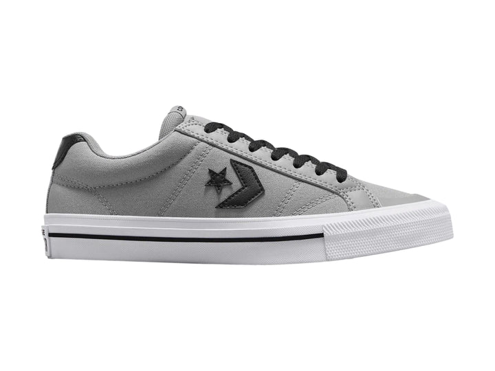 Tenis Converse color gris con suela blanca y detalles en negro, vista lateral.