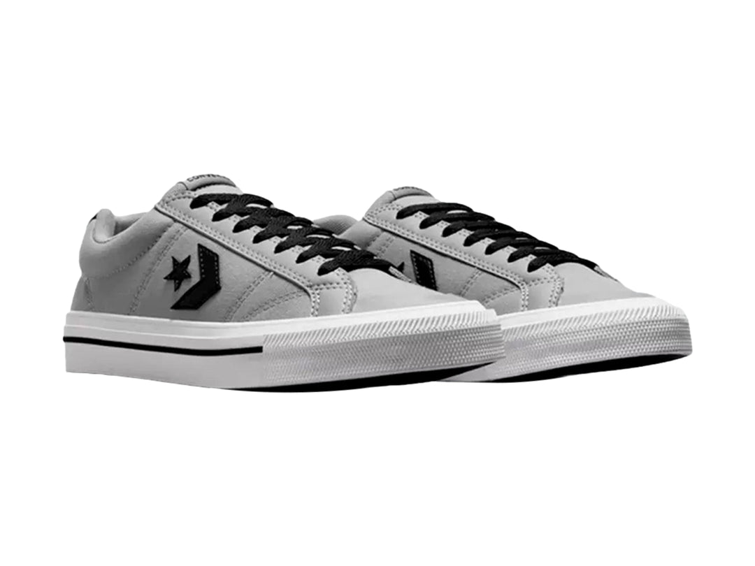Tenis Converse color gris con suela blanca y detalles en negro, vista lateral.