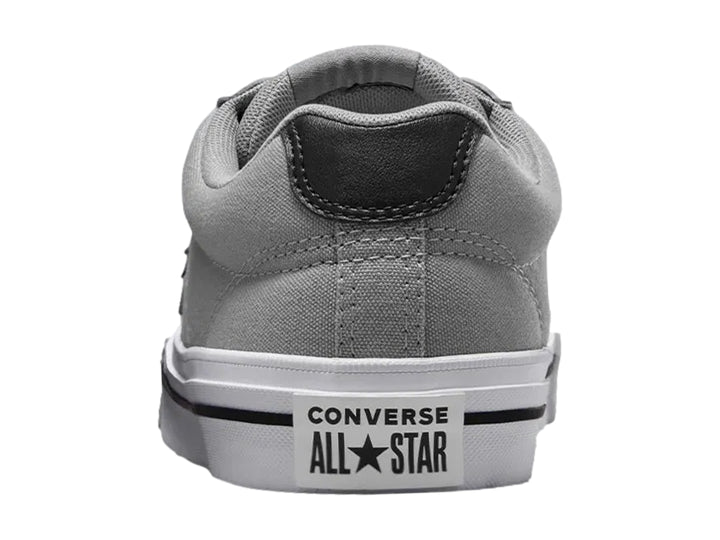 Tenis Converse color gris con suela blanca y detalles en negro, vista lateral.
