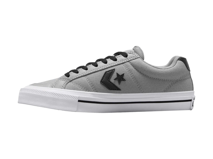 Tenis Converse color gris con suela blanca y detalles en negro, vista lateral.