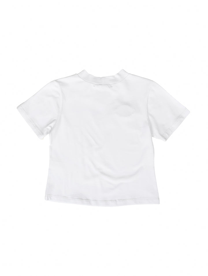 Blusa blanca para niña de manga corta con adorno brillante en forma de ojo y flecos en el pecho.