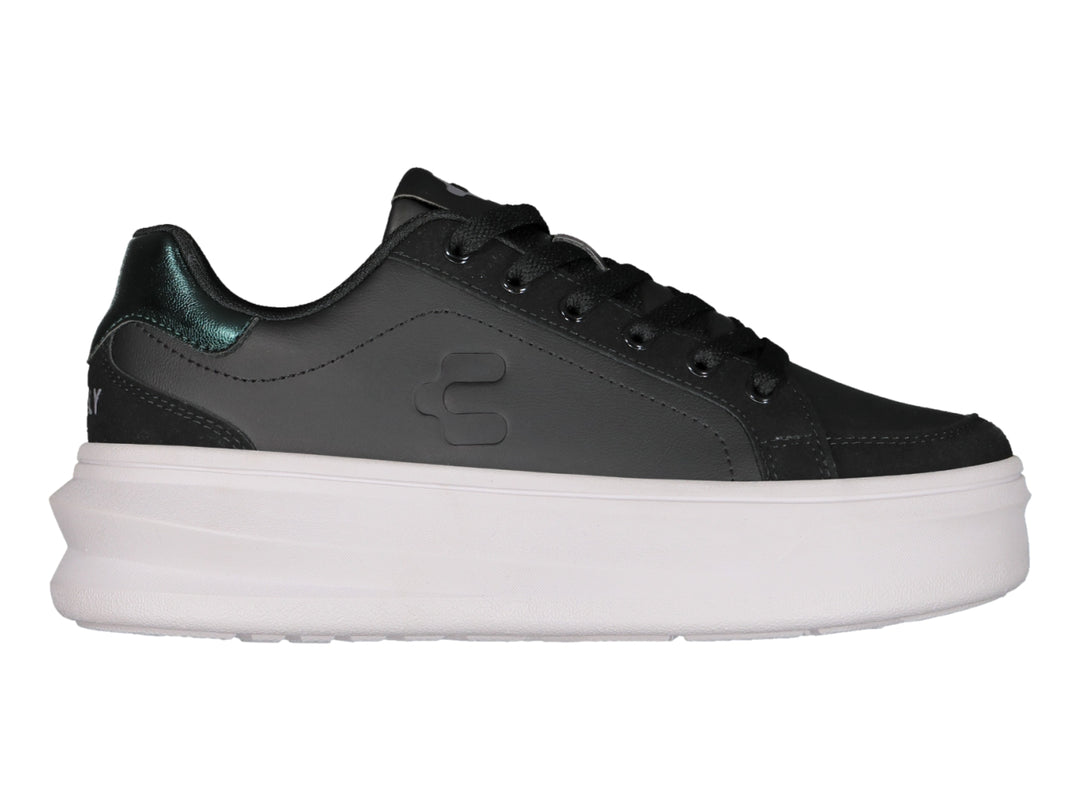 Tenis negros de plataforma con suela blanca y detalle metálico en el talón.