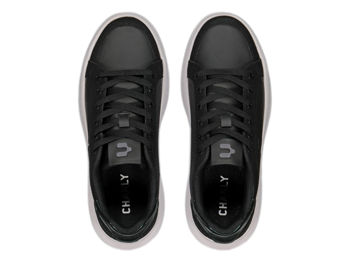 Tenis negros de plataforma con suela blanca y detalle metálico en el talón.
