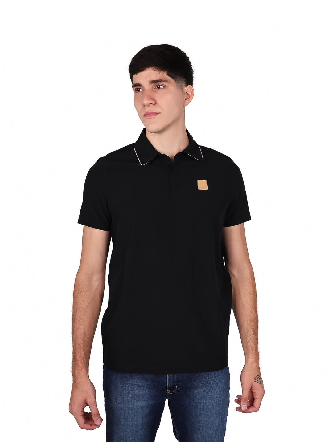 Hombre vistiendo una playera tipo polo de color negro con un pequeño detalle marrón en el pecho.