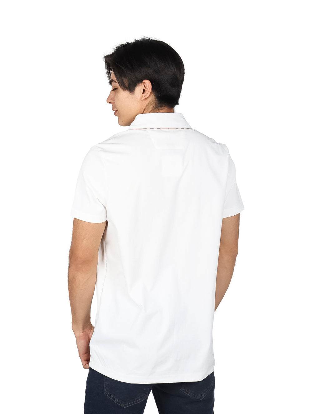 Hombre vistiendo una playera polo blanca de manga corta con un pequeño detalle beige en el pecho.