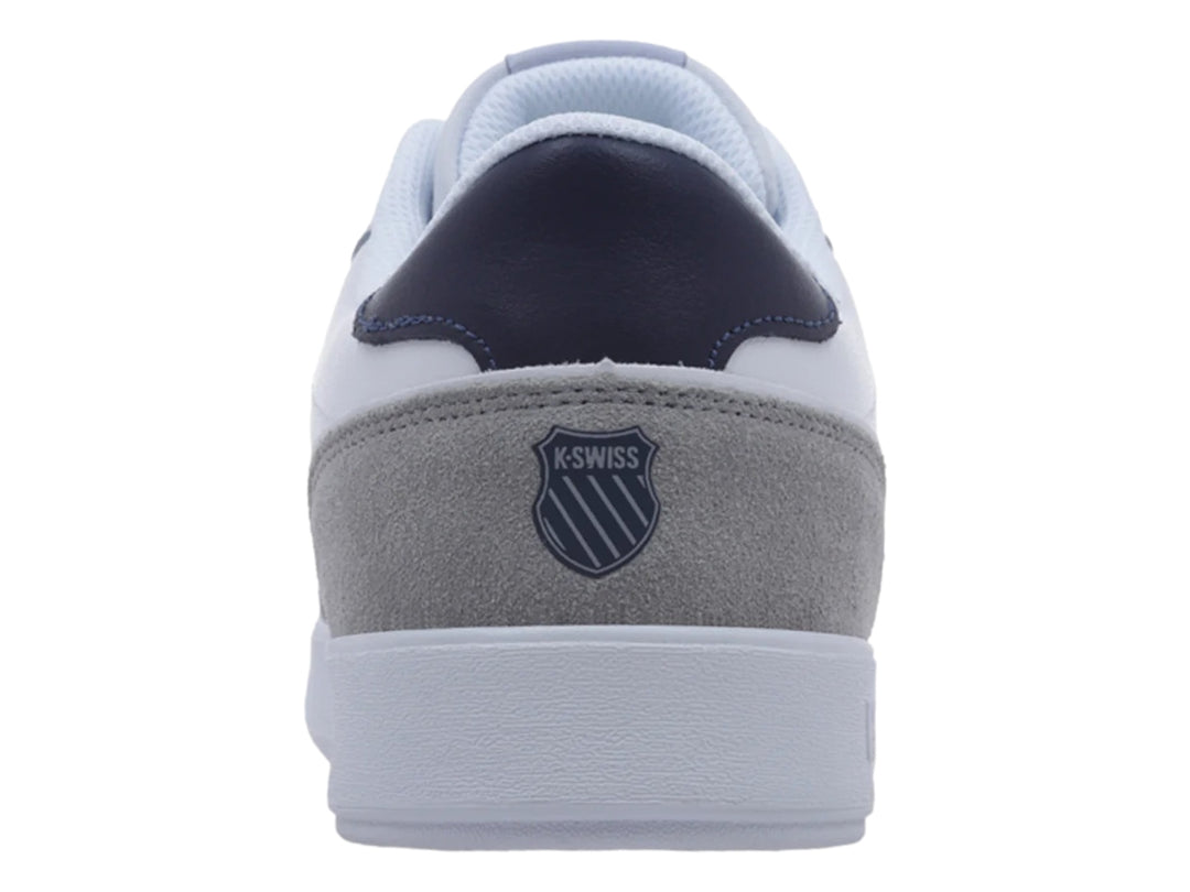 Tenis K-Swiss blancos con detalles en gris y azul marino, diseño casual deportivo.