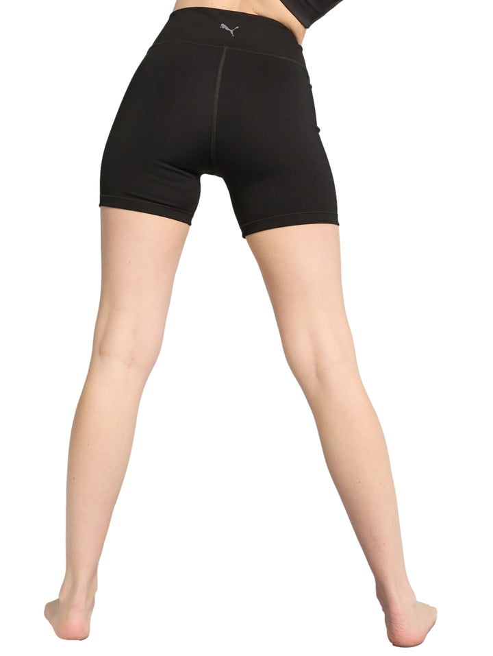 Mujer vistiendo biker shorts negros ajustados de la marca Puma.