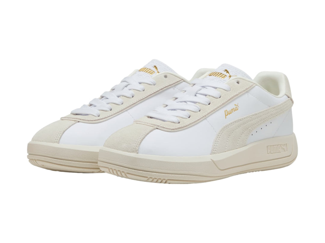 Tenis PUMA Club Klassika color blanco y crema con suela plana y cordones.