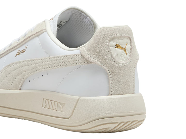 Tenis PUMA Club Klassika color blanco y crema con suela plana y cordones.