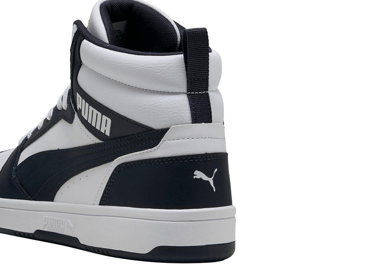 Tenis PUMA Rebound V6 de bota alta en colores blanco y azul marino con suela blanca.