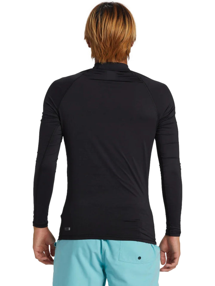 Hombre usando playera deportiva de manga larga color negro marca Quiksilver.