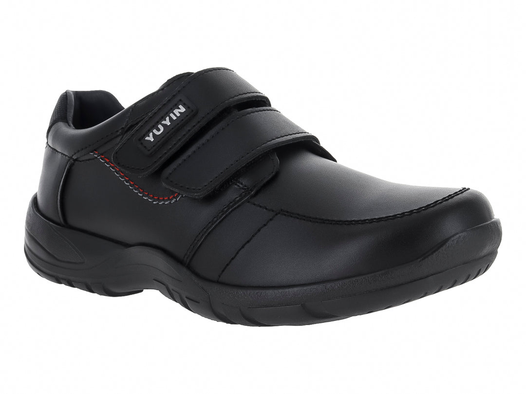 Zapato negro para niño con cierre de velcro y detalle de costura roja lateral.