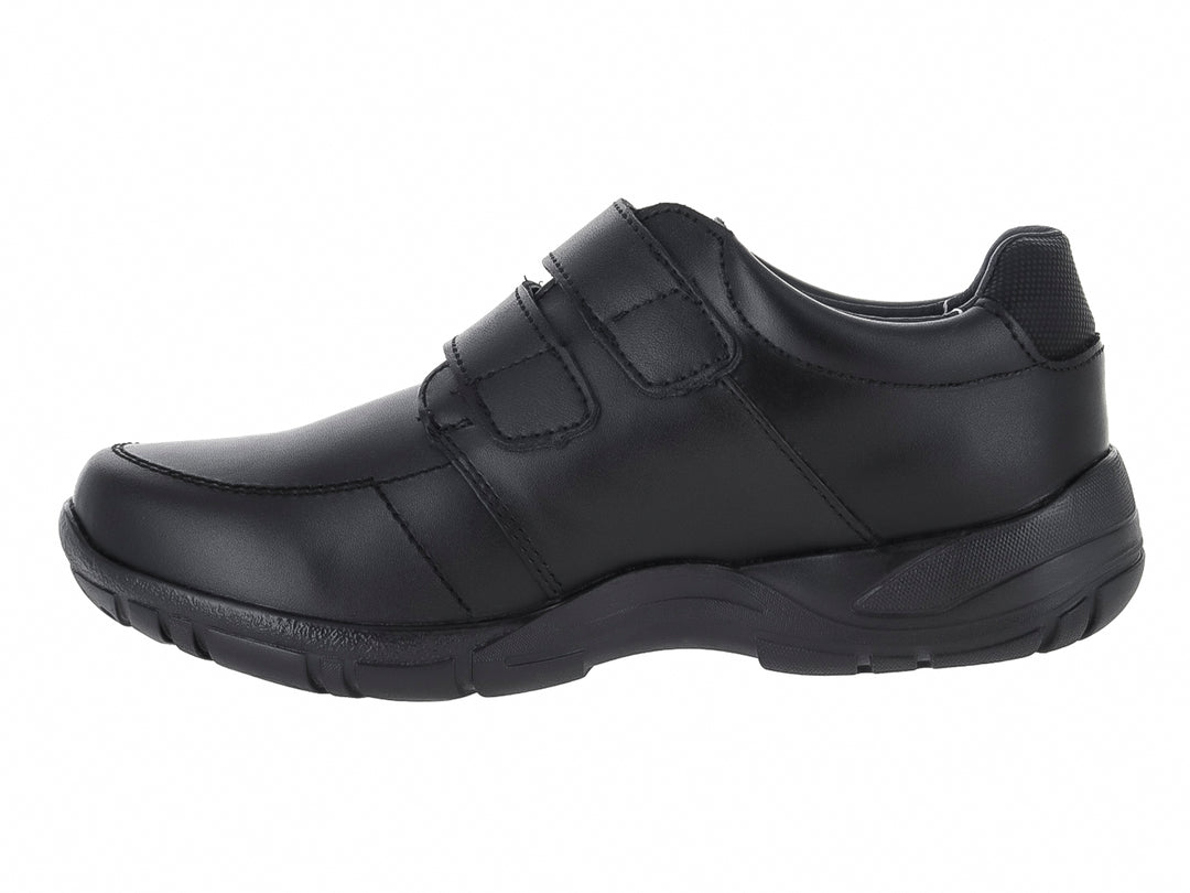 Zapato negro para niño con cierre de velcro y detalle de costura roja lateral.