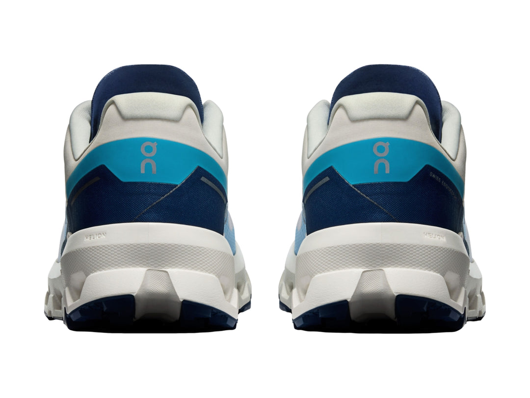 Tenis deportivos On Cloud en colores blanco y azul con suela amortiguada y malla transpirable.