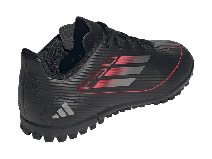 Tenis de fútbol Adidas F50 Club TF en color negro con detalles en rojo y gris, vista lateral.