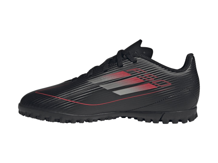Tenis de fútbol Adidas F50 Club TF en color negro con detalles en rojo y gris, vista lateral.