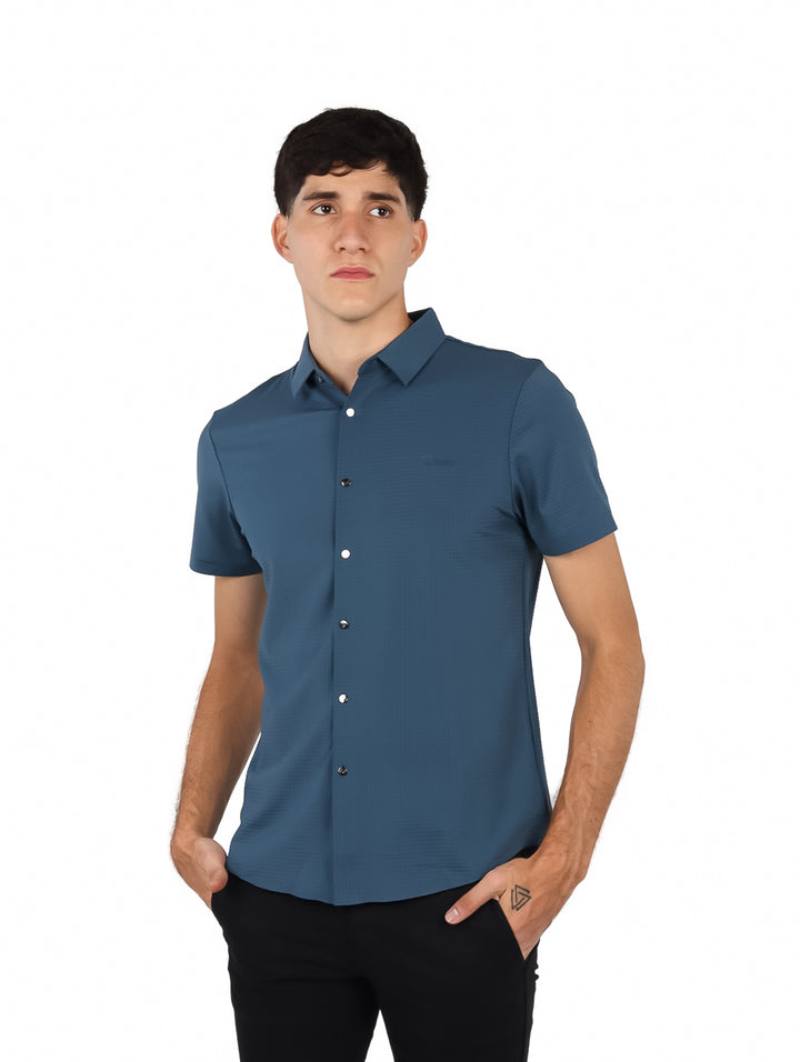 Hombre vistiendo una camisa de manga corta color azul rey con cuello y botones frontales.