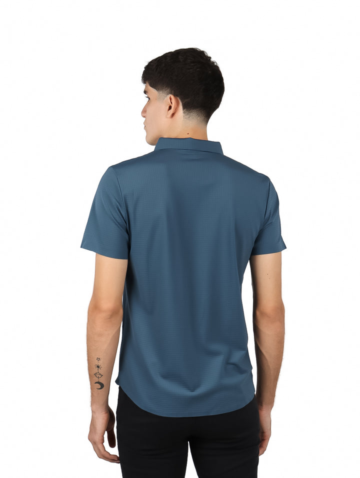 Hombre vistiendo una camisa de manga corta color azul rey con cuello y botones frontales.