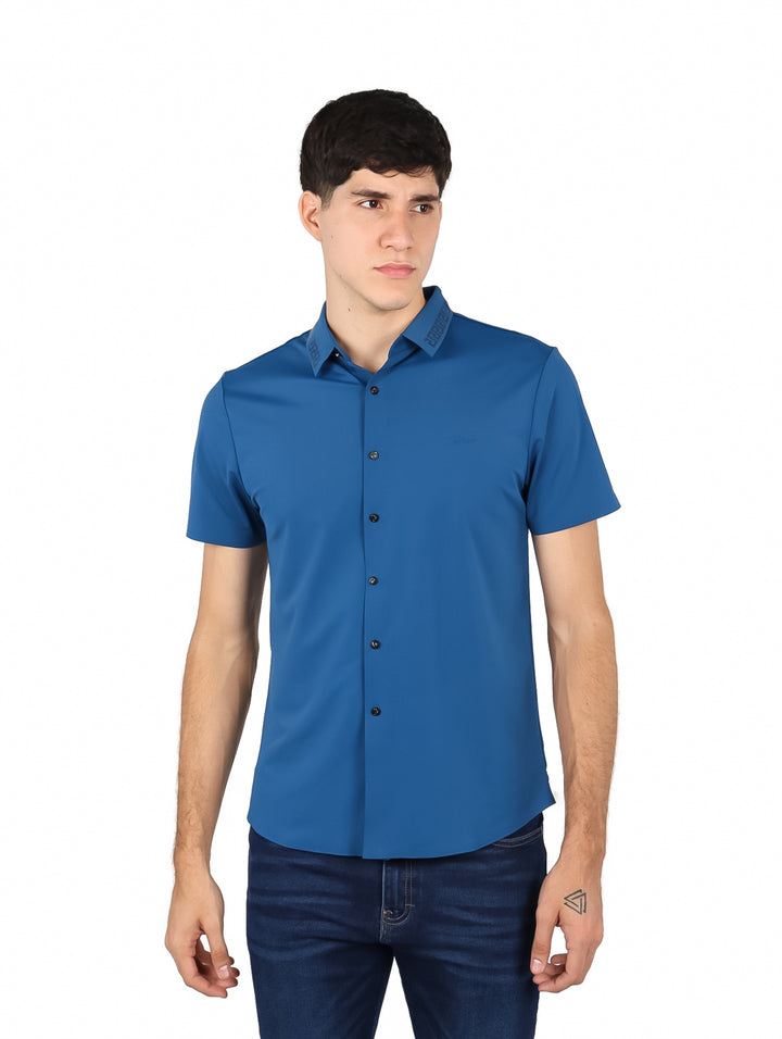 Hombre vistiendo una camisa de manga corta color verde fruta con botones frontales.
