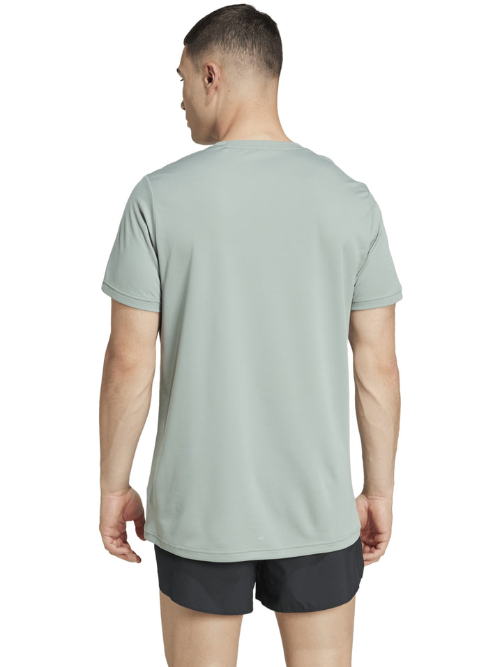 Hombre vistiendo playera deportiva Adidas color verde claro con logo blanco y shorts negros.