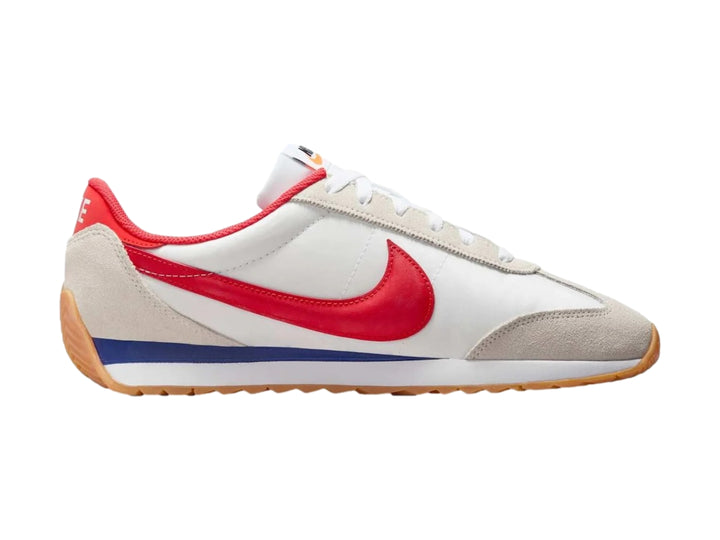 Tenis Nike blancos con detalles en gris, suela color miel y logotipo rojo en el costado.