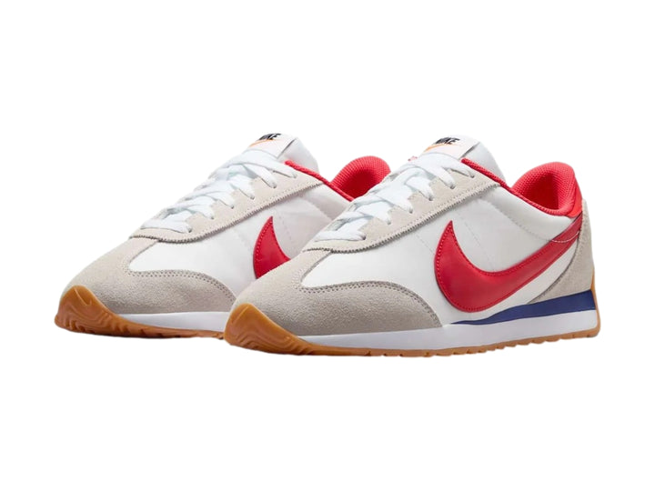 Tenis Nike blancos con detalles en gris, suela color miel y logotipo rojo en el costado.
