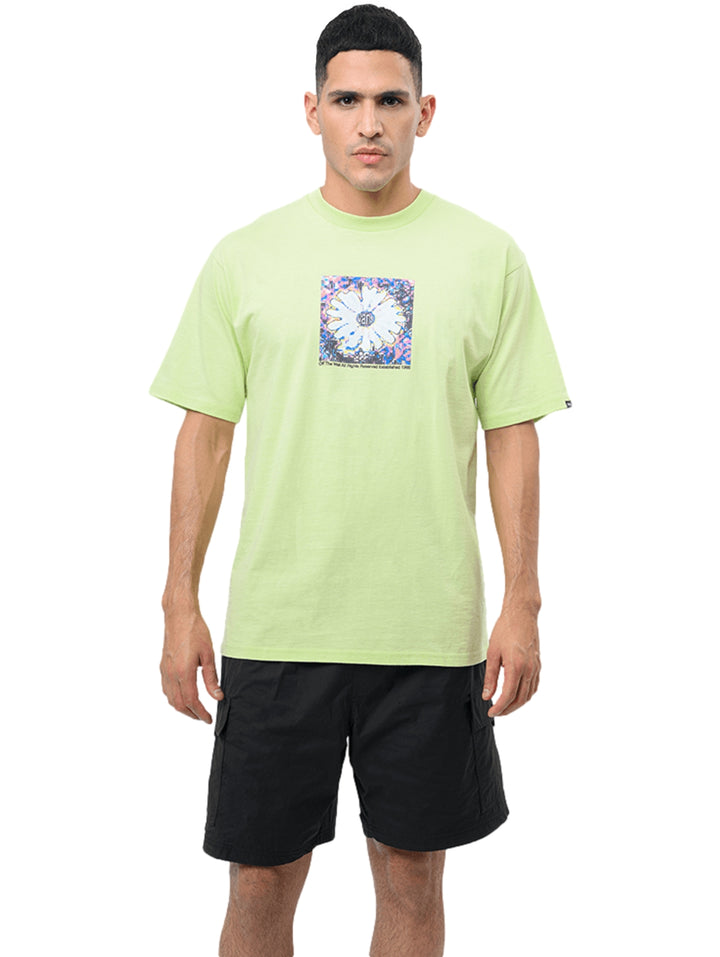 Hombre vistiendo camiseta VANS color verde lima con un estampado gráfico colorido en el centro del pecho.