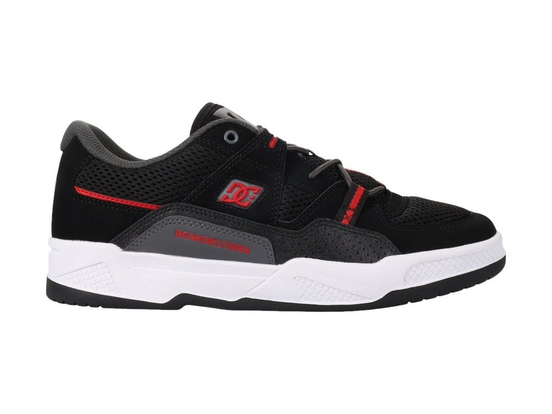 Tenis deportivos DC Shoes en color negro con detalles rojos y suela blanca.