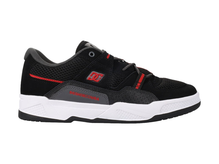 Tenis deportivos DC Shoes en color negro con detalles rojos y suela blanca.