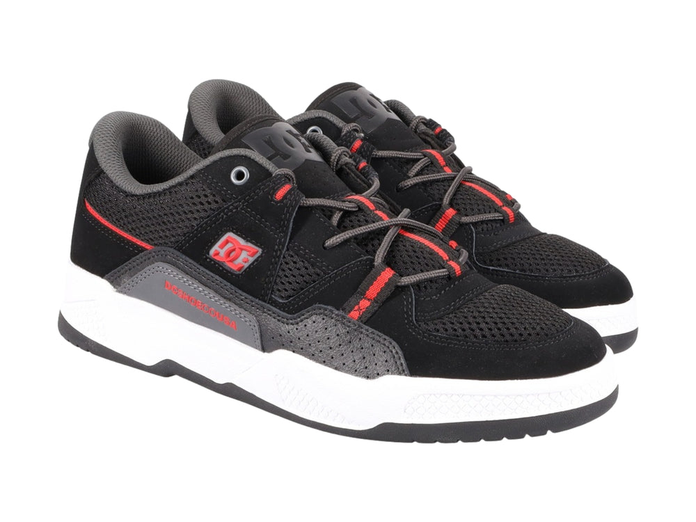 Tenis deportivos DC Shoes en color negro con detalles rojos y suela blanca.
