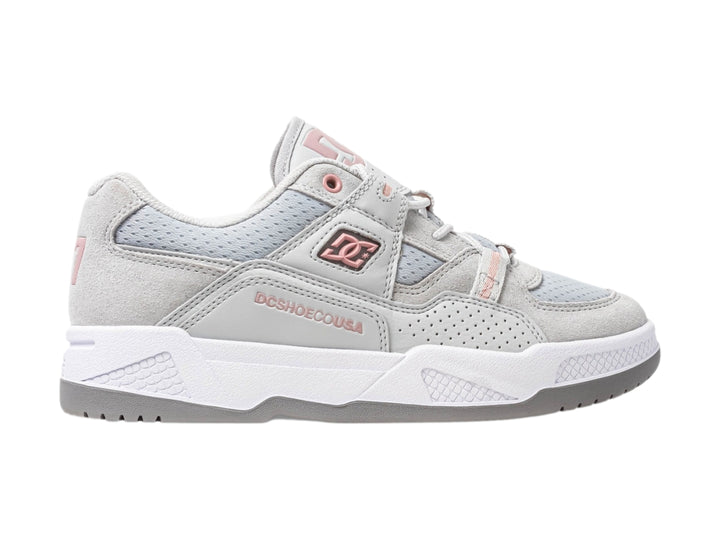 Tenis DC Shoes en color gris con detalles en rosa y suela blanca, vista lateral.