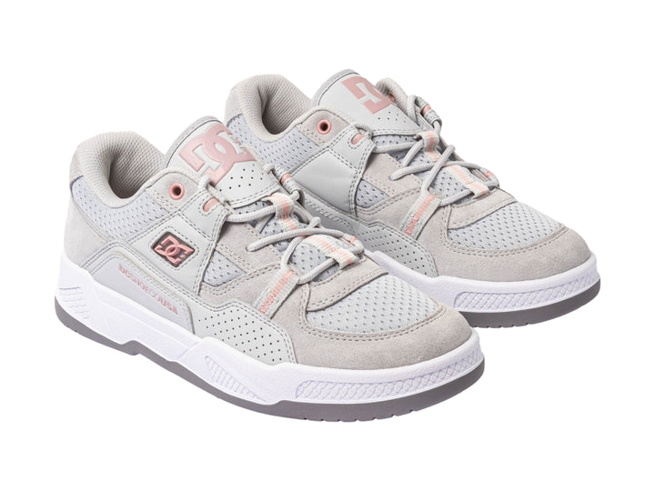 Tenis DC Shoes en color gris con detalles en rosa y suela blanca, vista lateral.