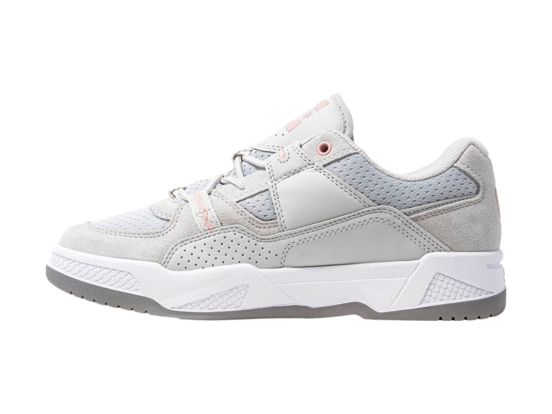 Tenis DC Shoes en color gris con detalles en rosa y suela blanca, vista lateral.