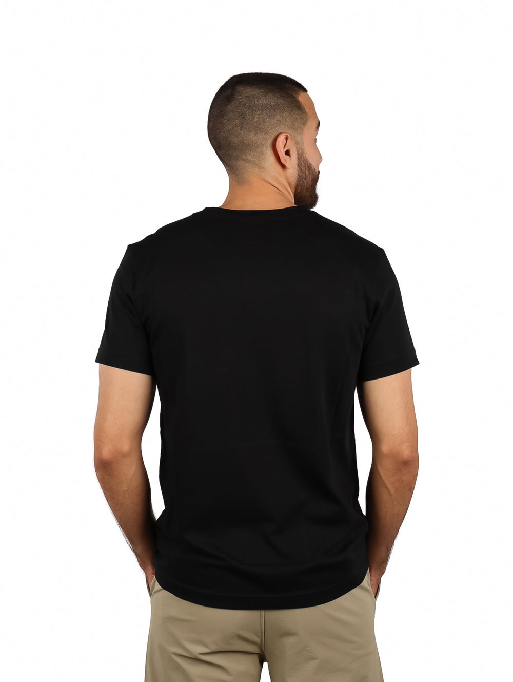 Hombre vistiendo camiseta negra de manga corta con un logotipo grande de cocodrilo en color kaki en el pecho.