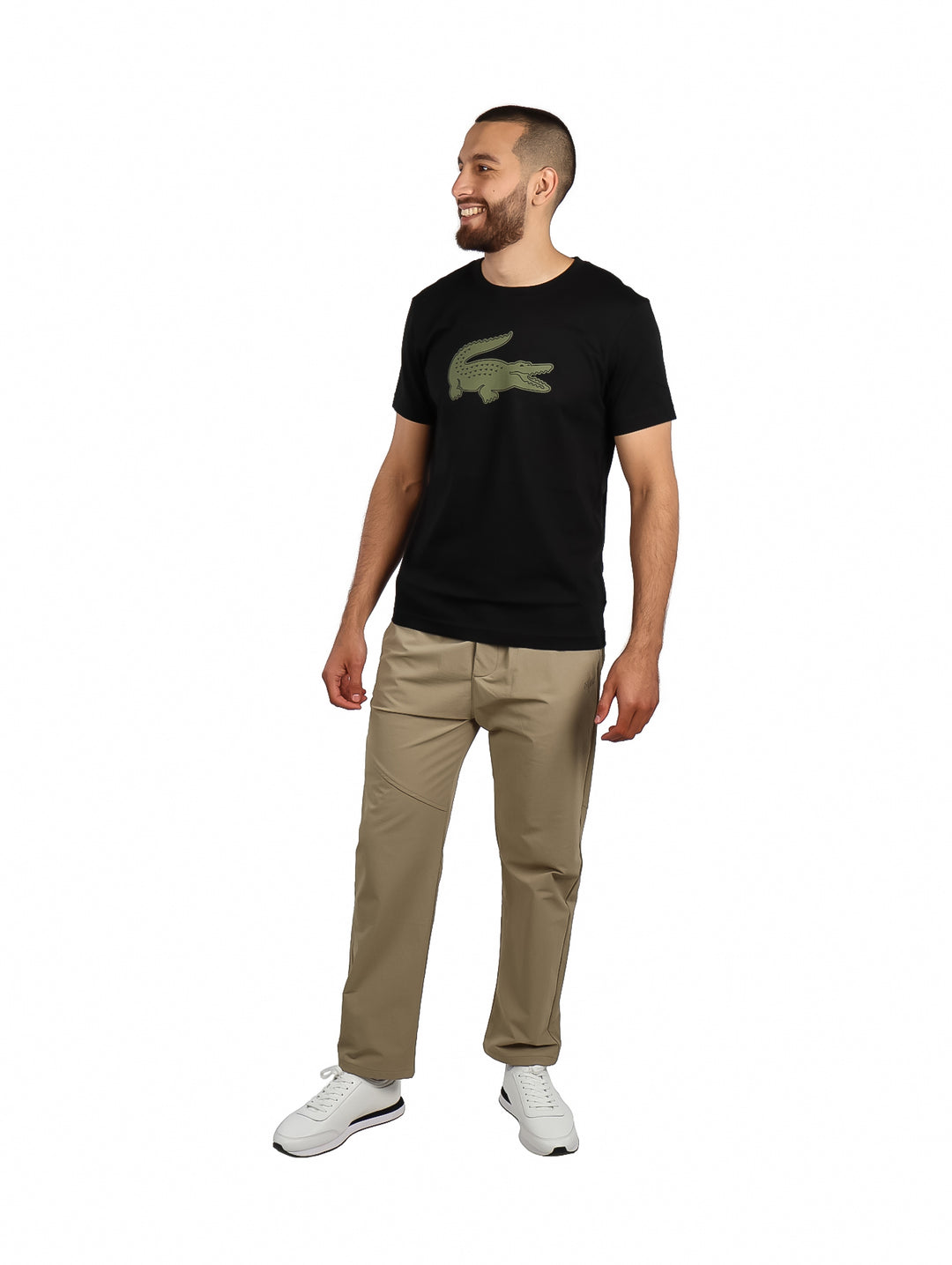 Hombre vistiendo camiseta negra de manga corta con un logotipo grande de cocodrilo en color kaki en el pecho.