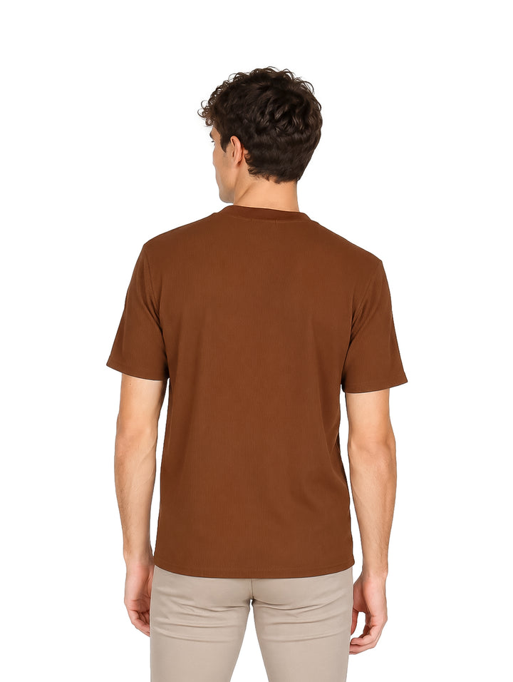 Hombre vistiendo una camiseta básica de color café con cuello redondo y manga corta.