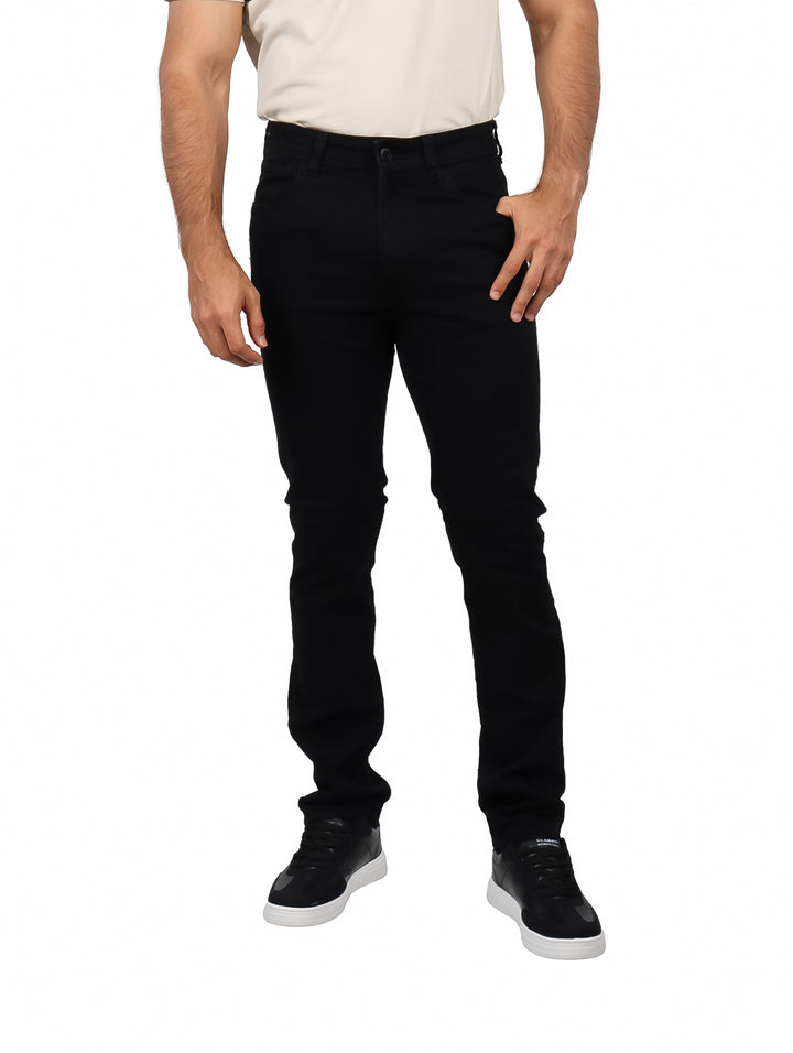 Hombre vistiendo pantalones jeans ajustados de color negro y calzado deportivo negro.
