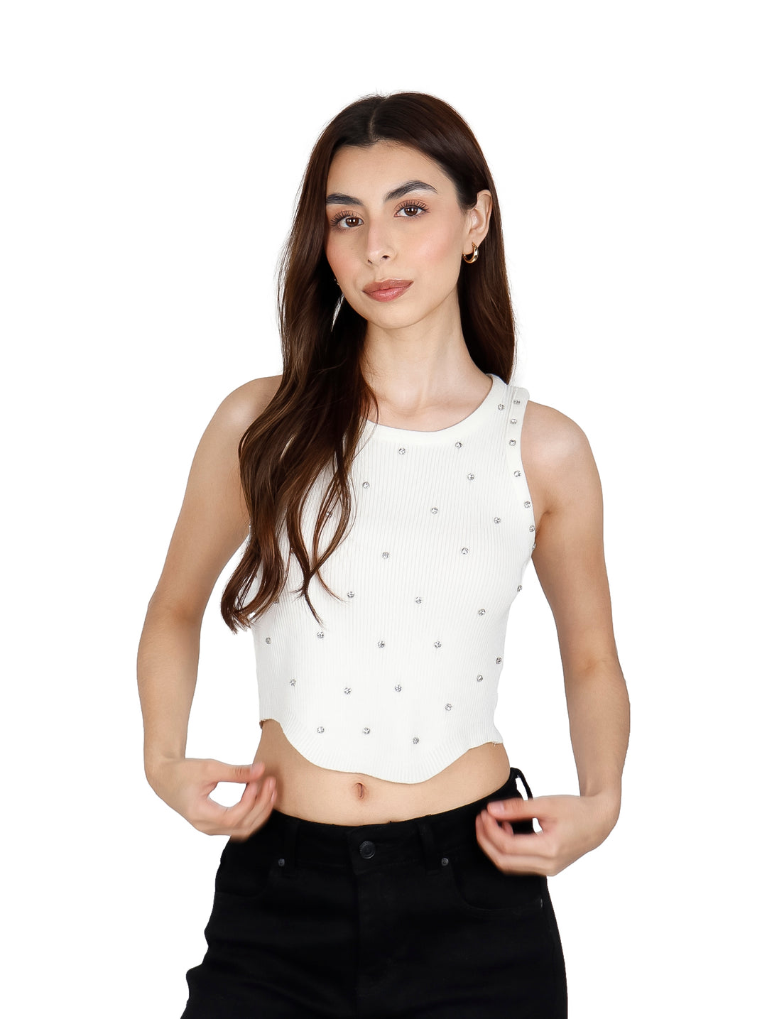 Mujer vistiendo un crop top blanco sin mangas con pequeños detalles brillantes y pantalones negros.