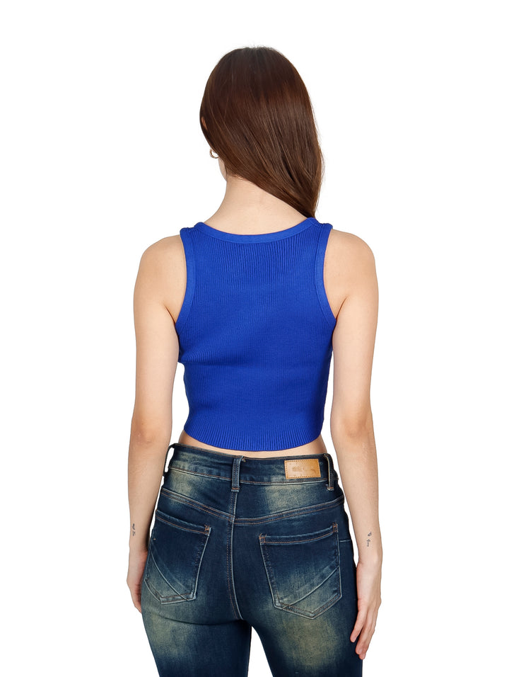 Mujer vistiendo un crop top azul royal acanalado con detalles brillantes y jeans azules.
