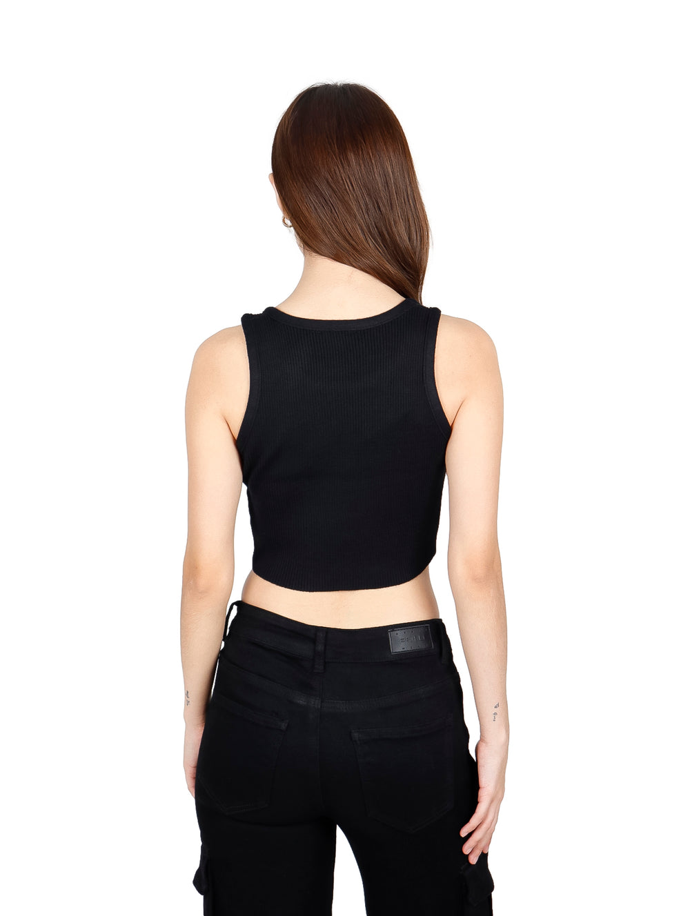 Mujer vistiendo un crop top negro sin mangas con pequeños detalles brillantes y pantalones negros.