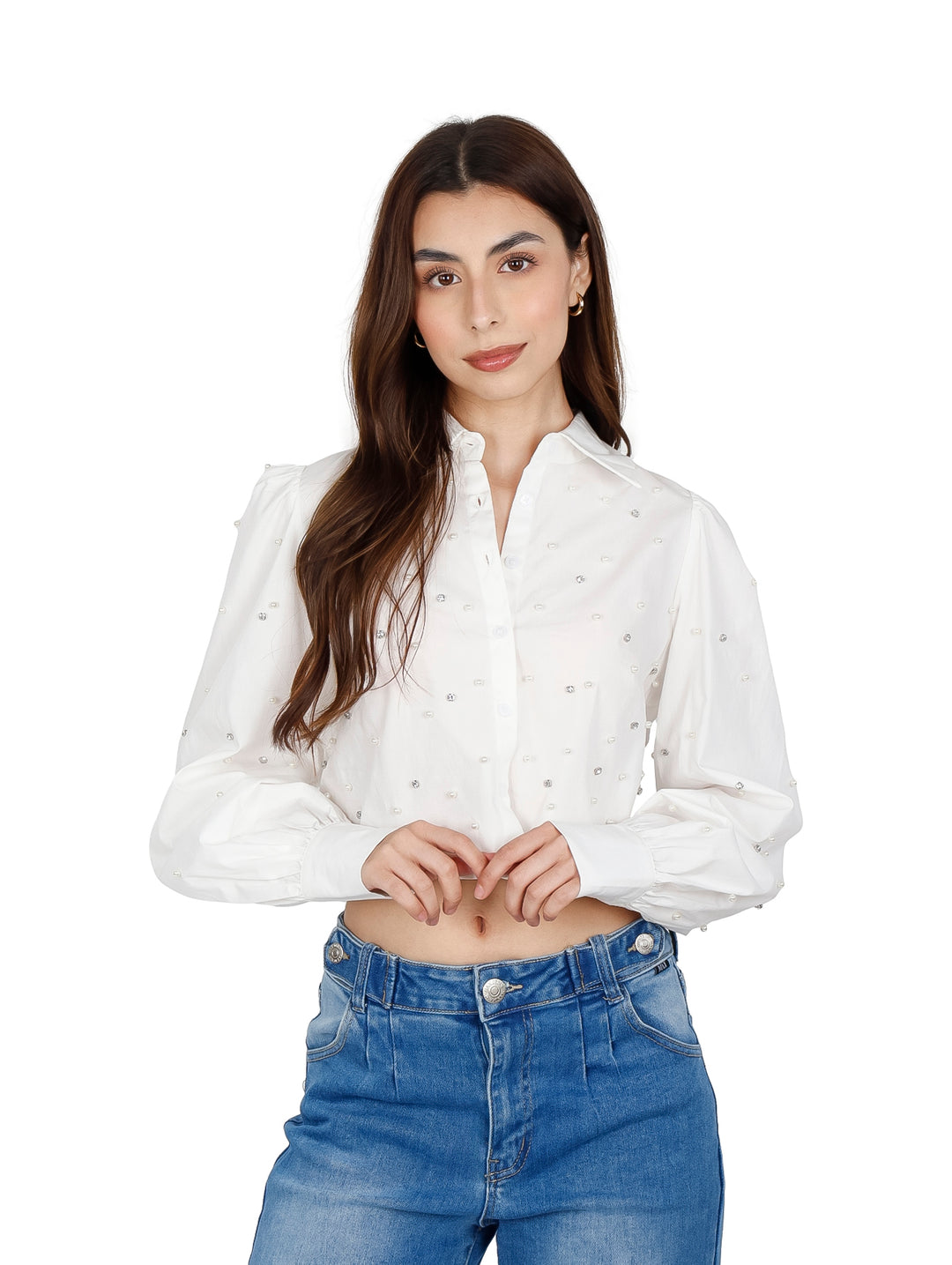 Mujer vistiendo una camisa crop top blanca con detalles de perlas y mangas largas.