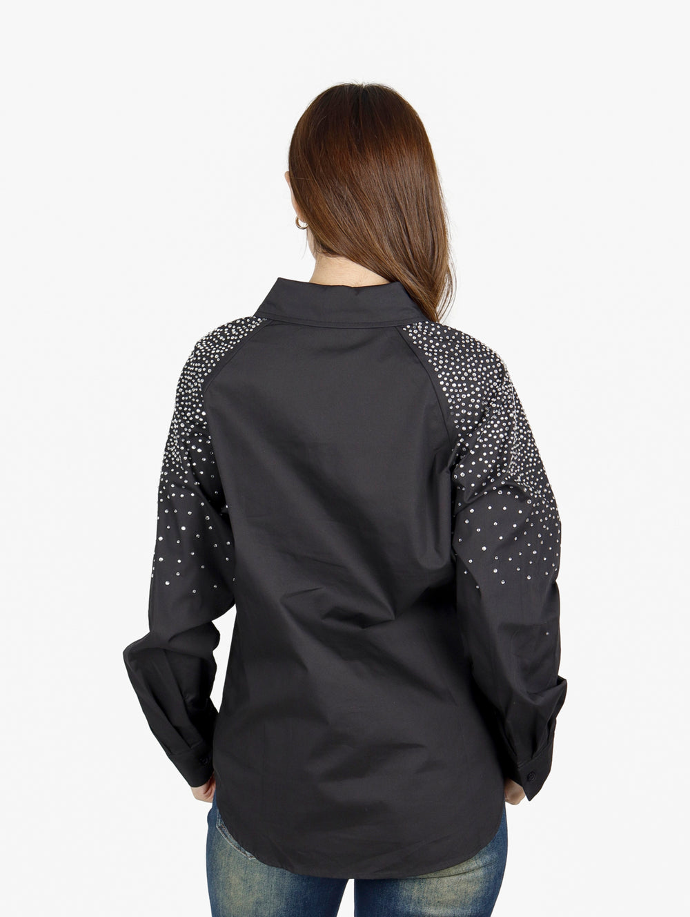 Mujer vistiendo camisa oversize color negro con detalles de puntos blancos en las mangas.
