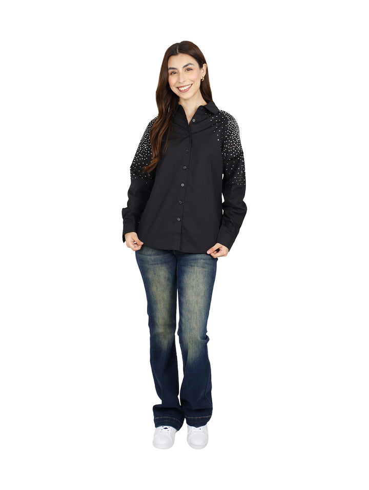Mujer vistiendo camisa oversize color negro con detalles de puntos blancos en las mangas.