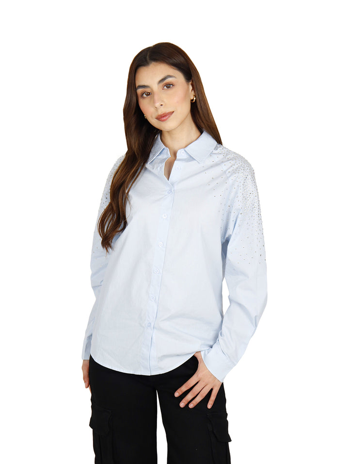 Camisa oversize color azul claro para mujer con detalles brillantes en el hombro.