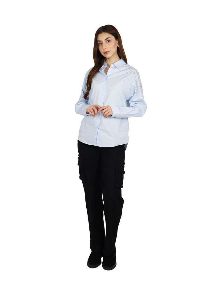 Camisa oversize color azul claro para mujer con detalles brillantes en el hombro.