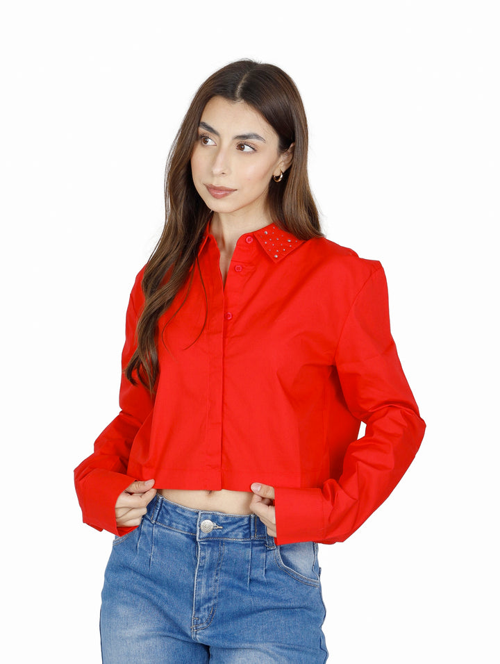 Mujer vistiendo una camisa roja corta de manga larga con botones.